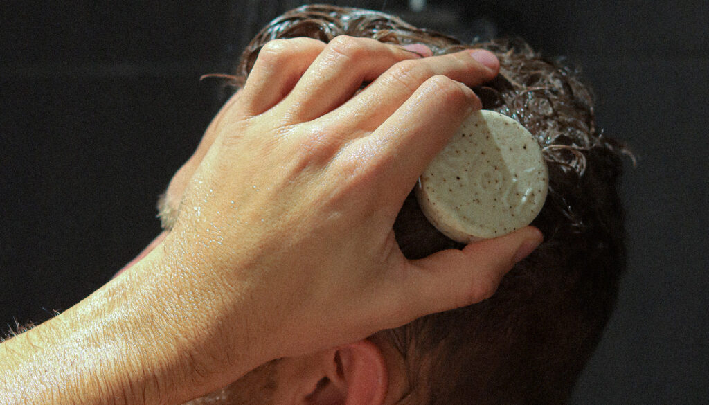 Mand bruger shampoo bar i vådt hår